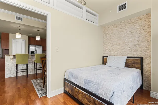 a bedroom with a bed and a table with wooden floor