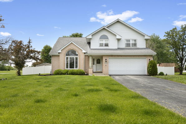 24222 Volbrecht Road Crete, IL 60417 - Photo 2 of 16 a view of a yard in front of a house with plants and large tree