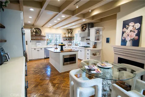 a living room with furniture a fireplace and kitchen view