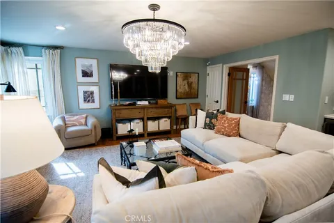 a living room with furniture a flat screen tv and a large window