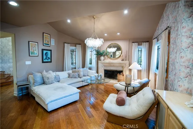 a living room with furniture a fireplace and a chandelier