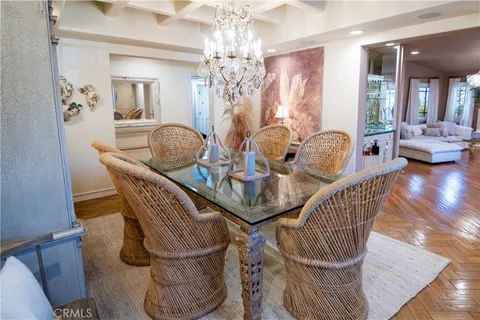 a dining room with furniture a chandelier and wooden floor