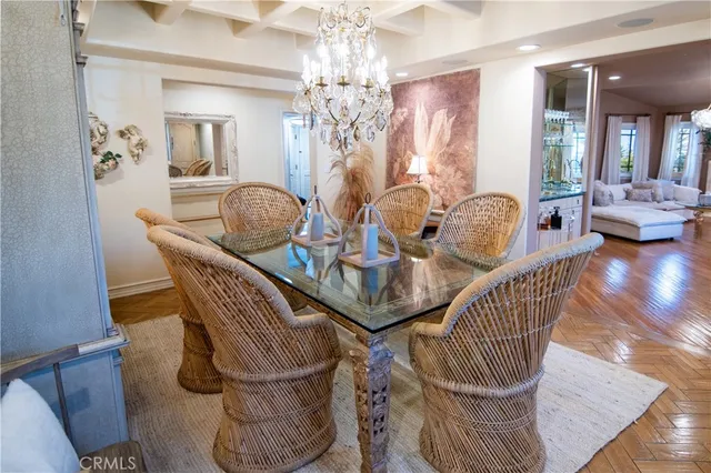 a dining room with furniture a chandelier and wooden floor