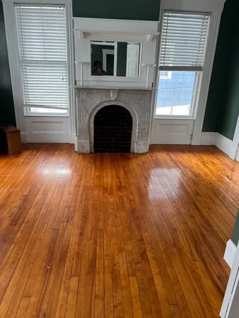 an empty room with wooden floor and a window