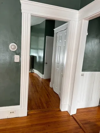 a view of a hallway with wooden floor and door