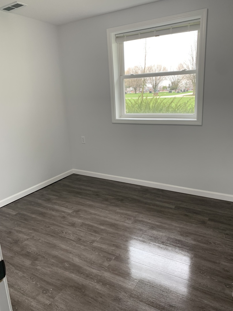 730 South High Street Paxton, IL 60957 - Photo 9 of 14 an empty room with wooden floor and a window