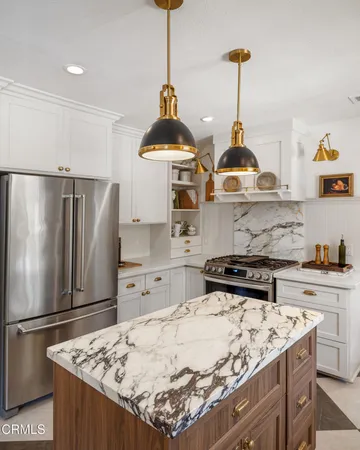 a kitchen with stainless steel appliances granite countertop a refrigerator a stove and a sink