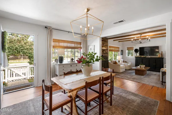 a dining room with furniture a chandelier and wooden floor