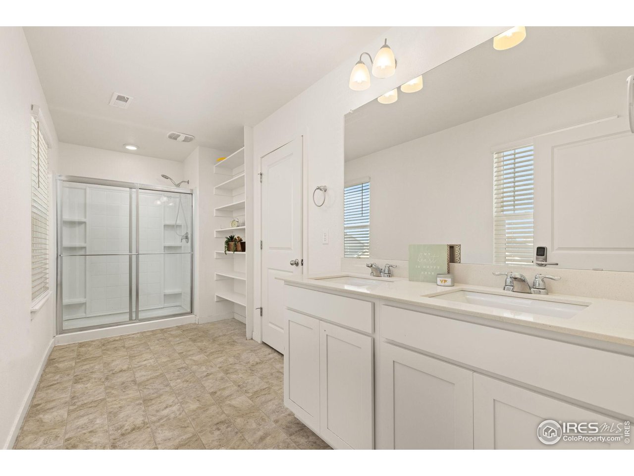 212 Swallow Road Johnstown, CO 80534 - Photo 21 of 32 Primary bath with double sinks, walk-in shower, and a generous window.