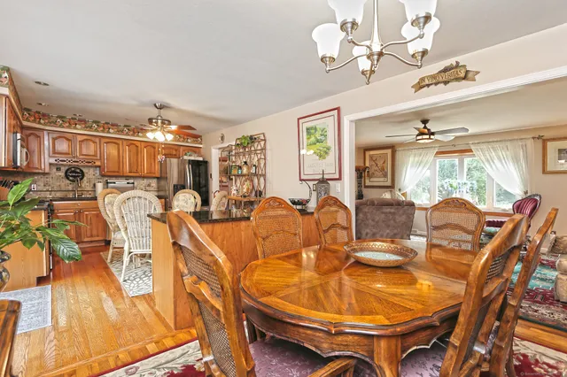 a dining room with furniture a chandelier and wooden floor