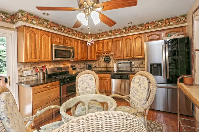 a kitchen with stainless steel appliances granite countertop a stove top oven a sink dishwasher and cabinets with wooden floor