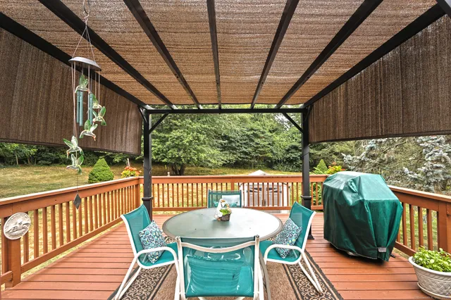 a roof deck with table and chairs and wooden floor