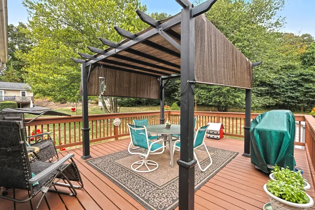 a view of a deck with furniture and a backyard