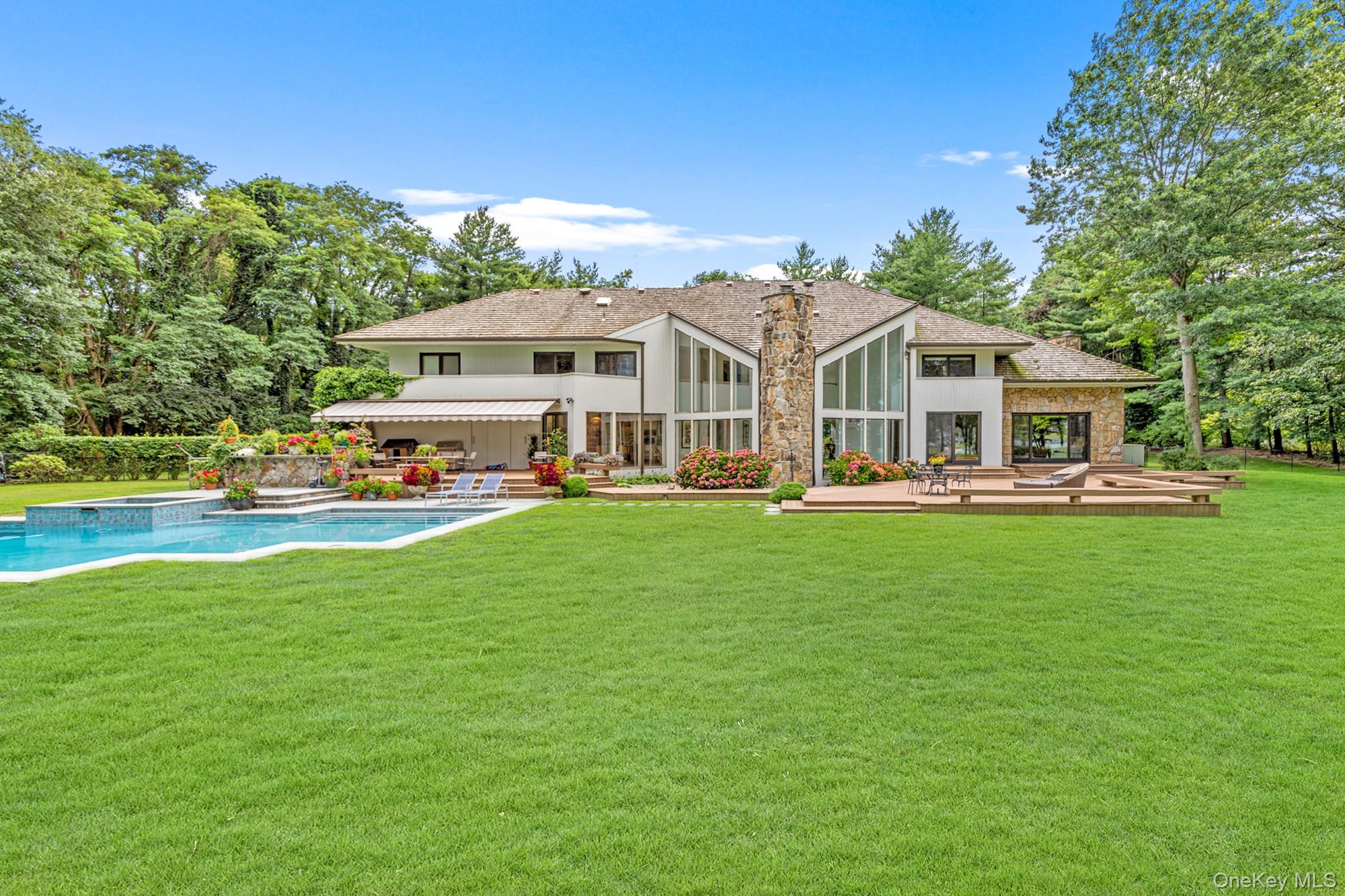 8 Mill Pond Lane Locust Valley, NY 11560 - Photo 33 of 38 a front view of a house with a yard table and chairs