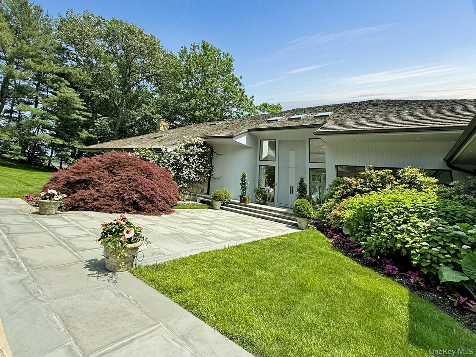 8 Mill Pond Lane Locust Valley, NY 11560 - Photo 34 of 38 a house with green field in front of it