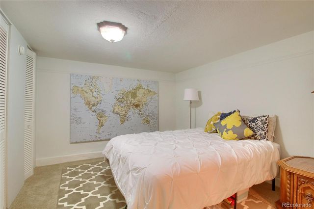 a bedroom with a bed and a painting on the wall