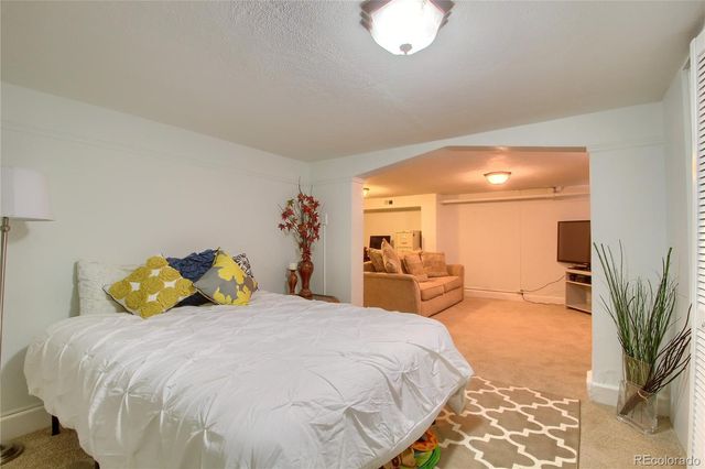 a bedroom with a bed and large mirror with potted plants