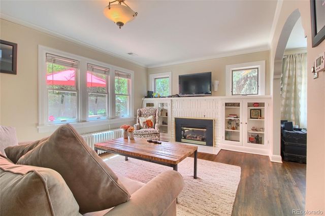a living room with furniture large window and a fireplace