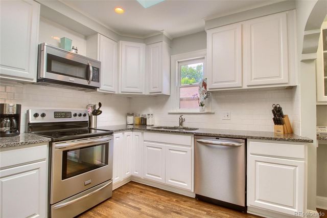 a kitchen with cabinets stainless steel appliances a sink and a stove