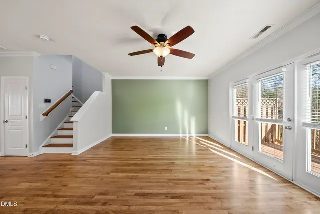 a view of a livingroom with a ceiling fan window and wooden floor