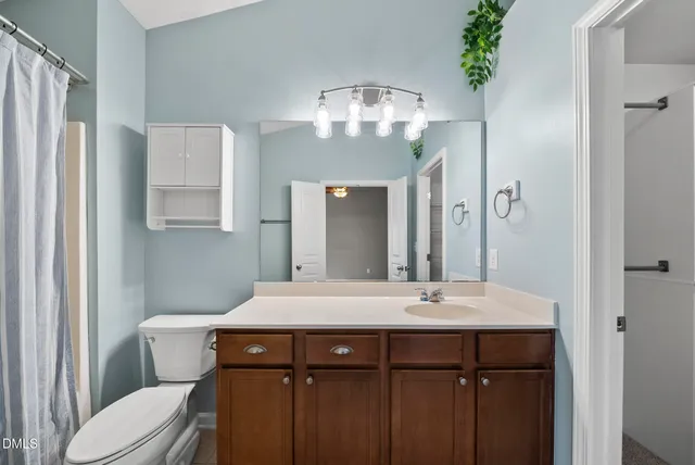 a bathroom with a bathtub shower sink vanity and toilet