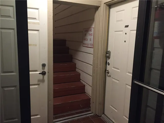 a view of staircase with white walls door