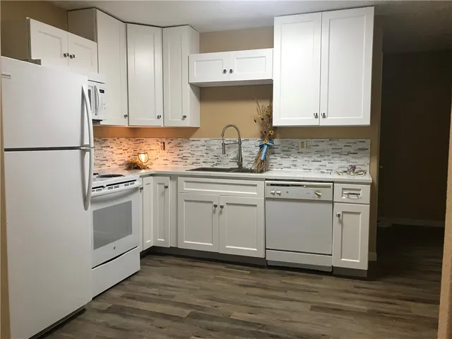 a kitchen with white cabinets and white appliances