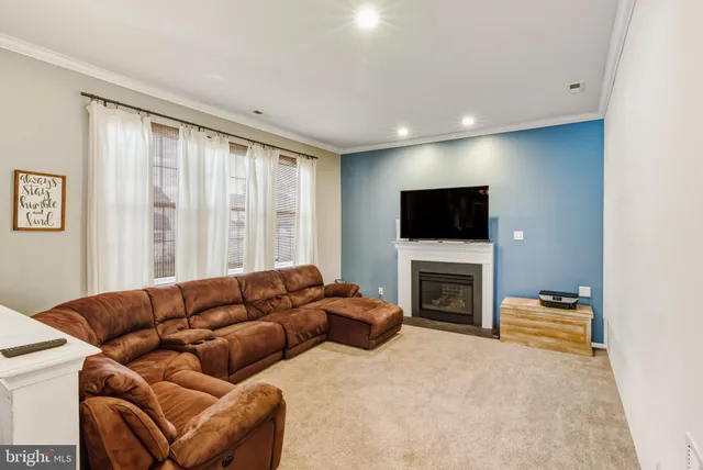 a living room with a flat screen tv a rug and a window