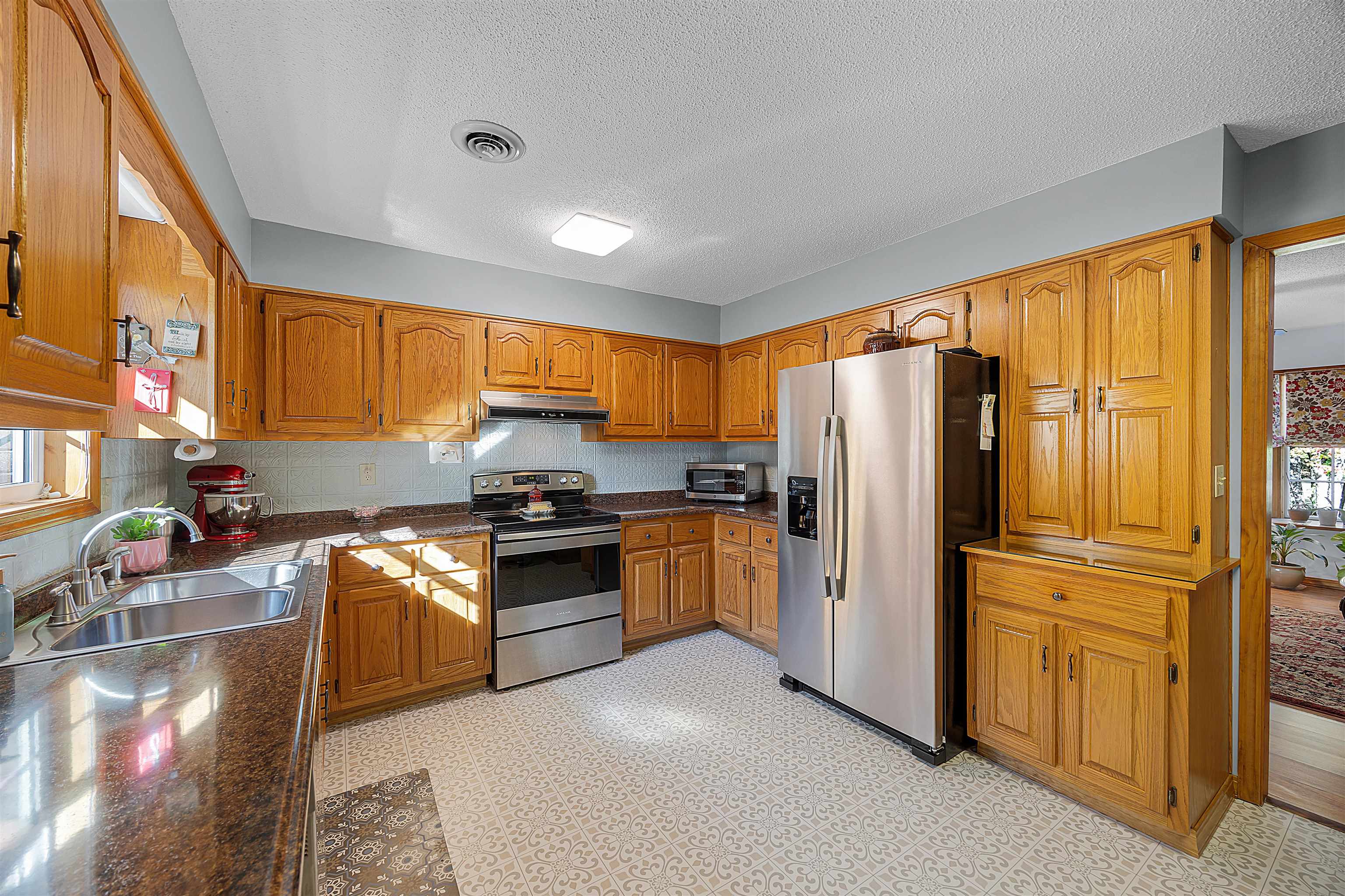 61 Cr 303 Road Iuka, MS 38852 - Photo 11 of 19 Kitchen featuring sink, stainless steel appliances, a textured ceiling, and dark stone counters