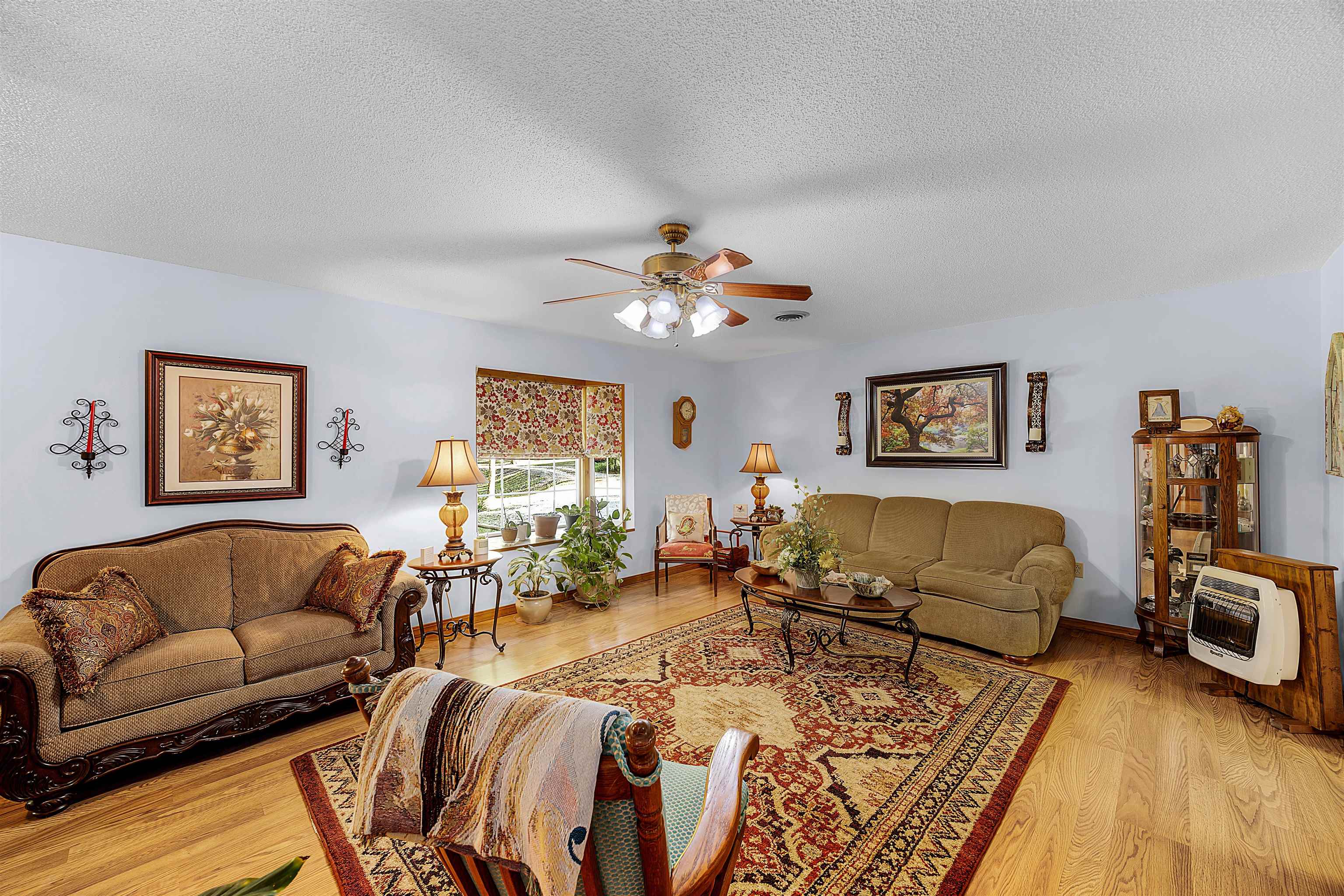 61 Cr 303 Road Iuka, MS 38852 - Photo 8 of 19 Living room with a textured ceiling, light hardwood / wood-style flooring, heating unit, and ceiling fan