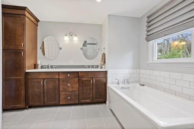a spacious bathroom with a tub sink and mirror