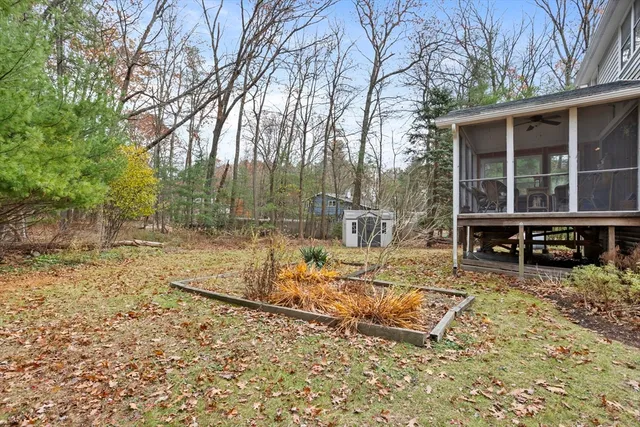 a view of backyard with wooden fence and large trees