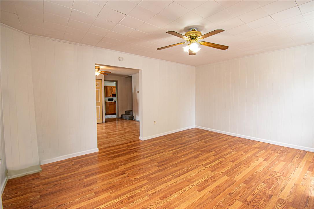 27 West Allen Street Allentown, PA 18102 - Photo 4 of 26 A well-lit living space showcasing durable hardwood flooring and a functional ceiling fan.