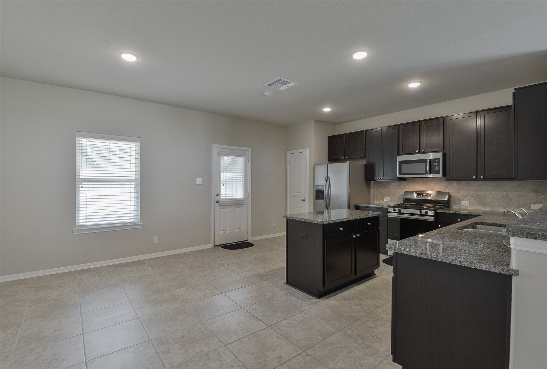 614 Pequin Road Crosby, TX 77532 - Photo 11 of 43 a kitchen with stainless steel appliances granite countertop a stove a sink a refrigerator a microwave and cabinets