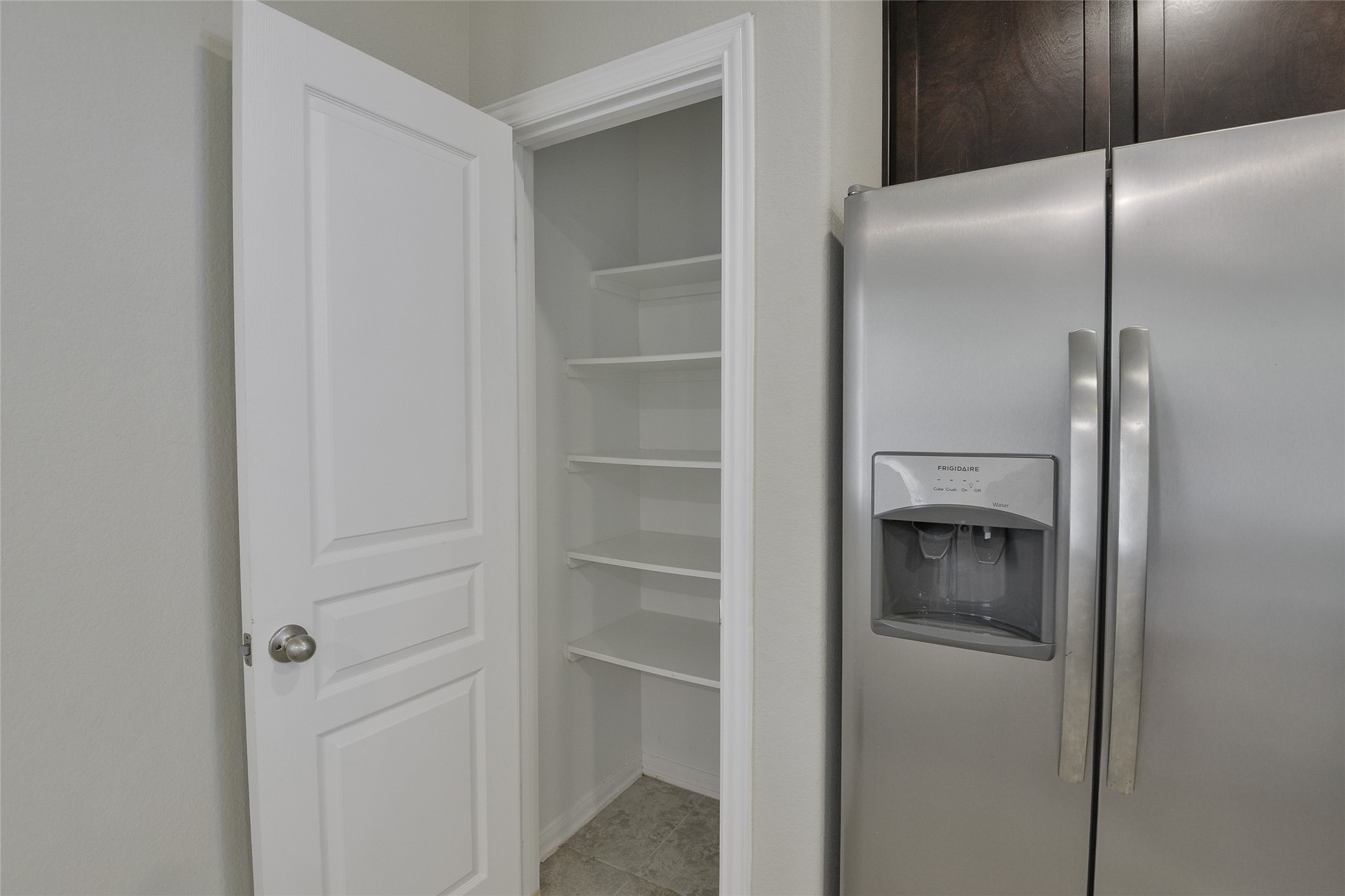 614 Pequin Road Crosby, TX 77532 - Photo 14 of 43 This photo shows a pantry with multiple shelves, located next to refrigerator space.