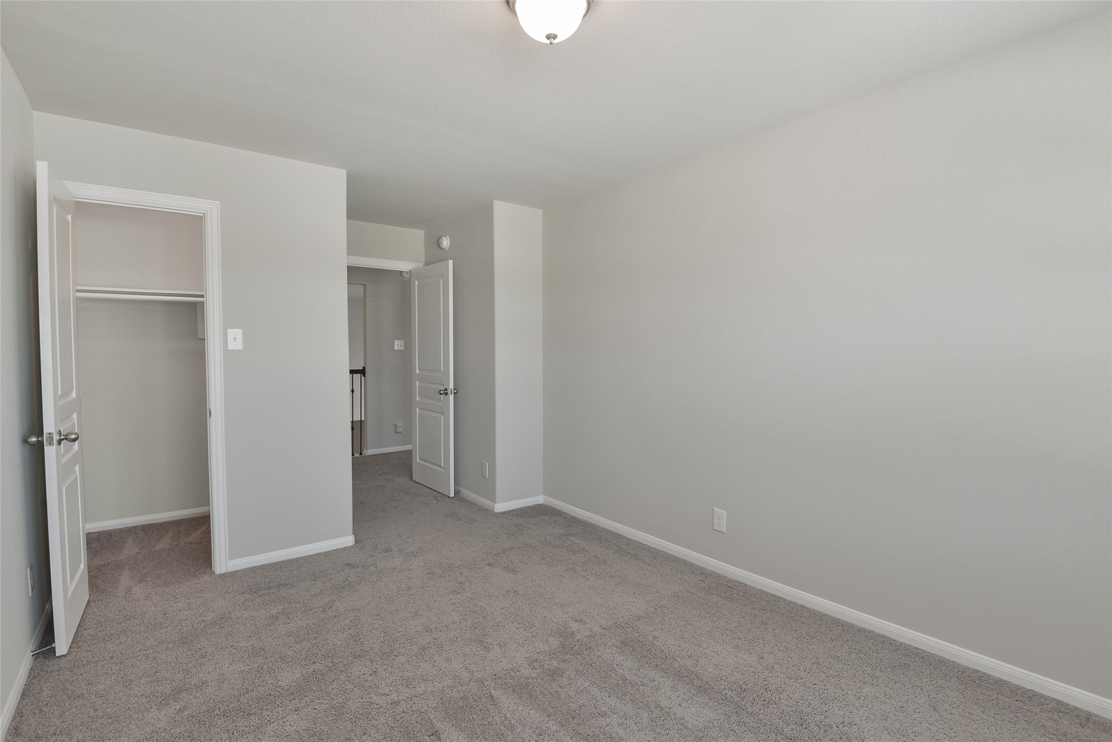 614 Pequin Road Crosby, TX 77532 - Photo 28 of 43 This is a bright, neutral-toned bedroom with carpeted flooring, featuring a walk-in closet and a ceiling light. It offers a clean, simple space ready for personalization.