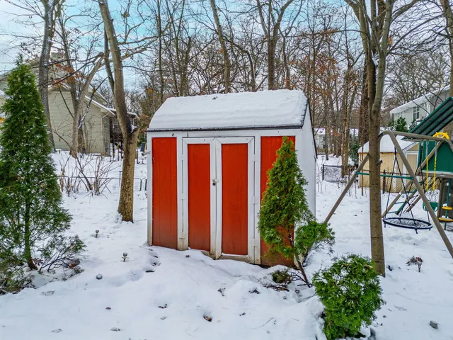 a view of a backyard with a slide trees and wooden fence