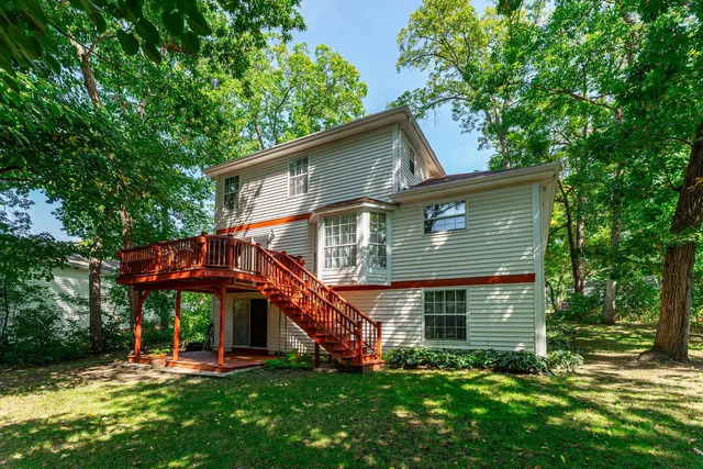 a front view of a house with a garden and trees