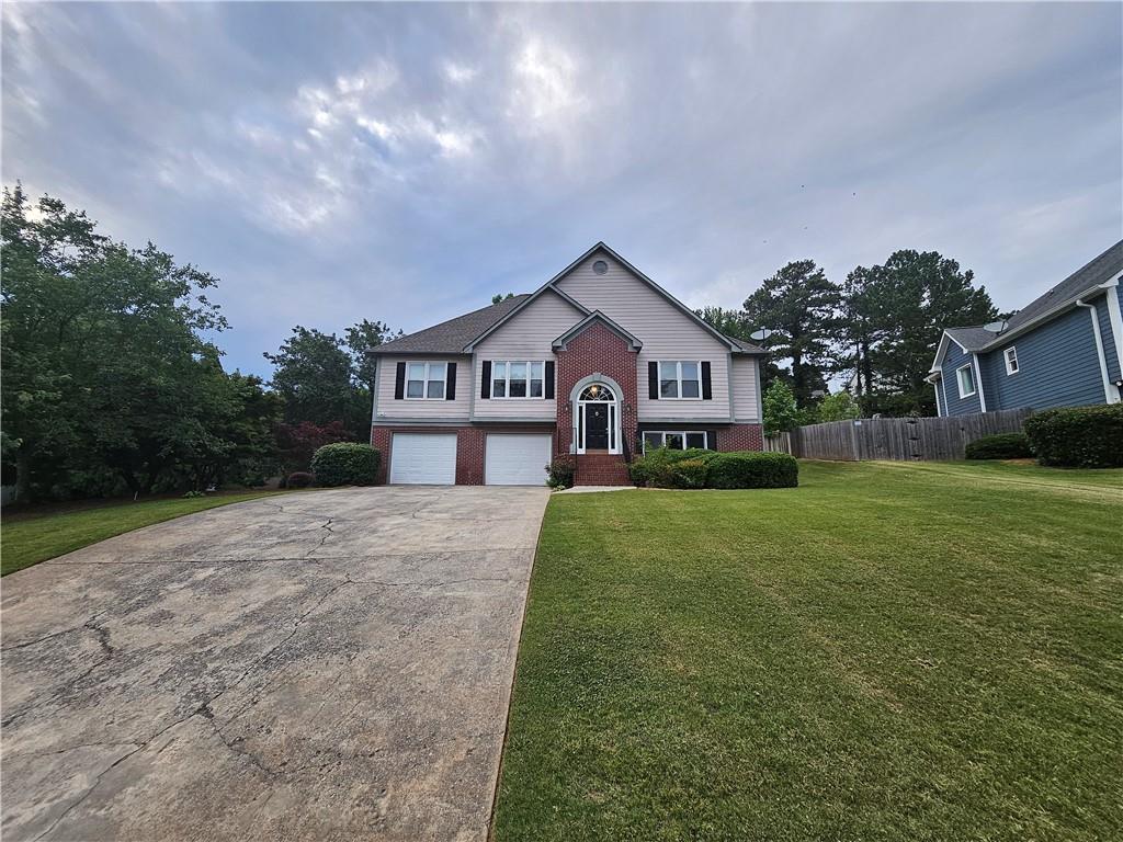 144 Hunters Trace Dallas, GA 30157 - Photo 2 of 34 a front view of a house with a yard and garage