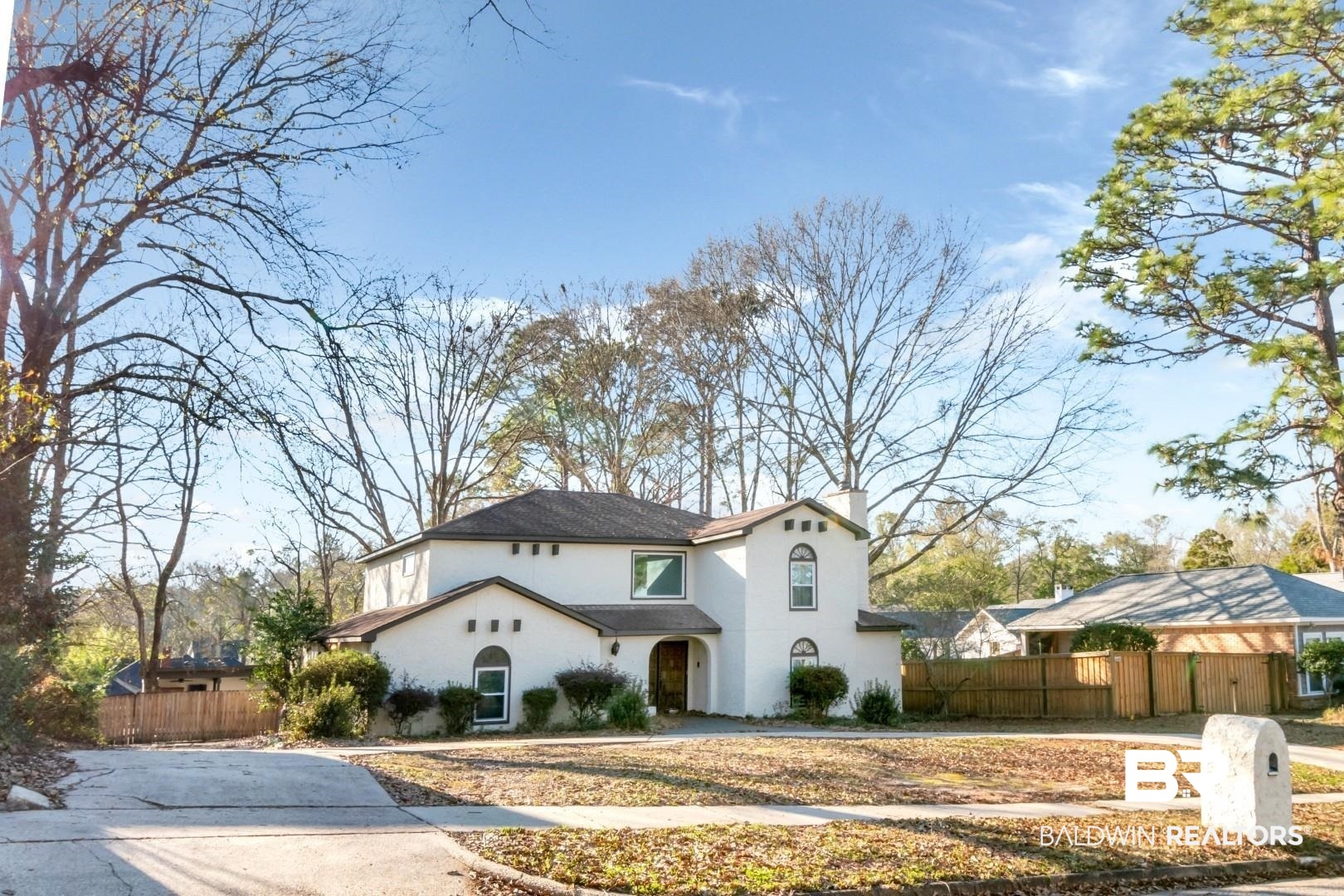 Mediterranean / spanish-style house with a fenced front yard, a chimney, and stucco siding