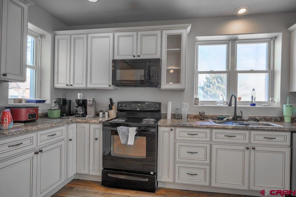 522 East First Street, Unit A & B Trinidad, CO 81082 - Photo 12 of 45 a kitchen with cabinets appliances a sink and a window