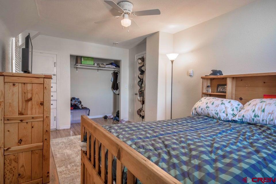 522 East First Street, Unit A & B Trinidad, CO 81082 - Photo 18 of 45 a bedroom with a large bed and a chandelier