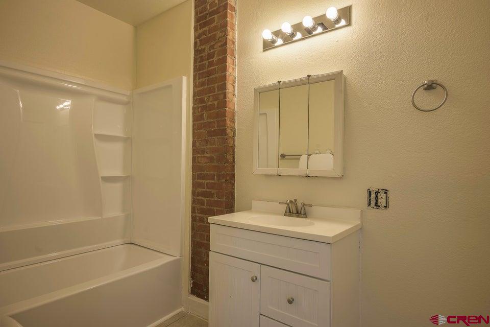 522 East First Street, Unit A & B Trinidad, CO 81082 - Photo 20 of 45 a bathroom with a granite countertop sink a toilet and shower