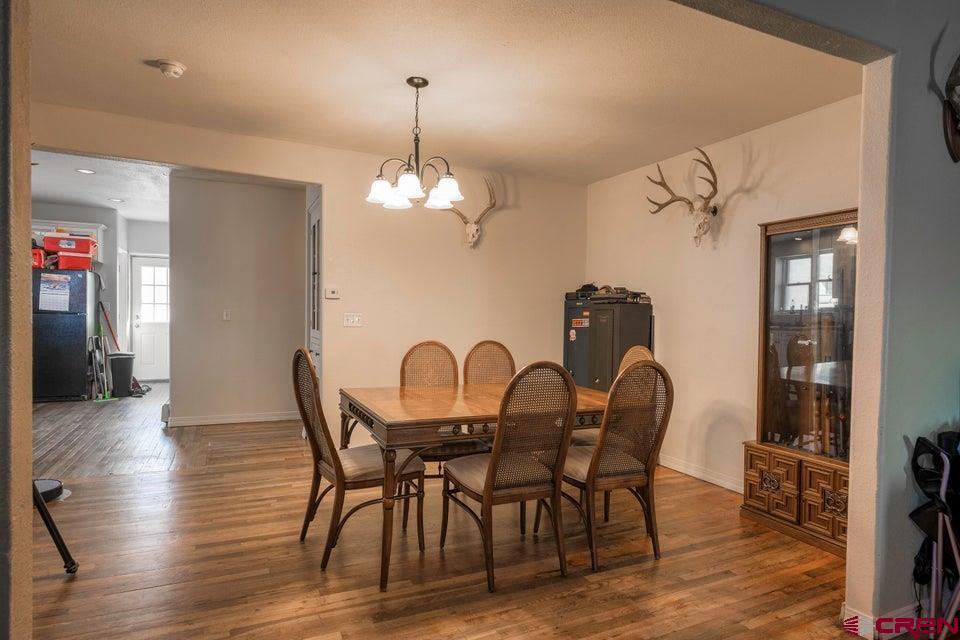 522 East First Street, Unit A & B Trinidad, CO 81082 - Photo 7 of 45 a dining room with furniture a chandelier and wooden floor