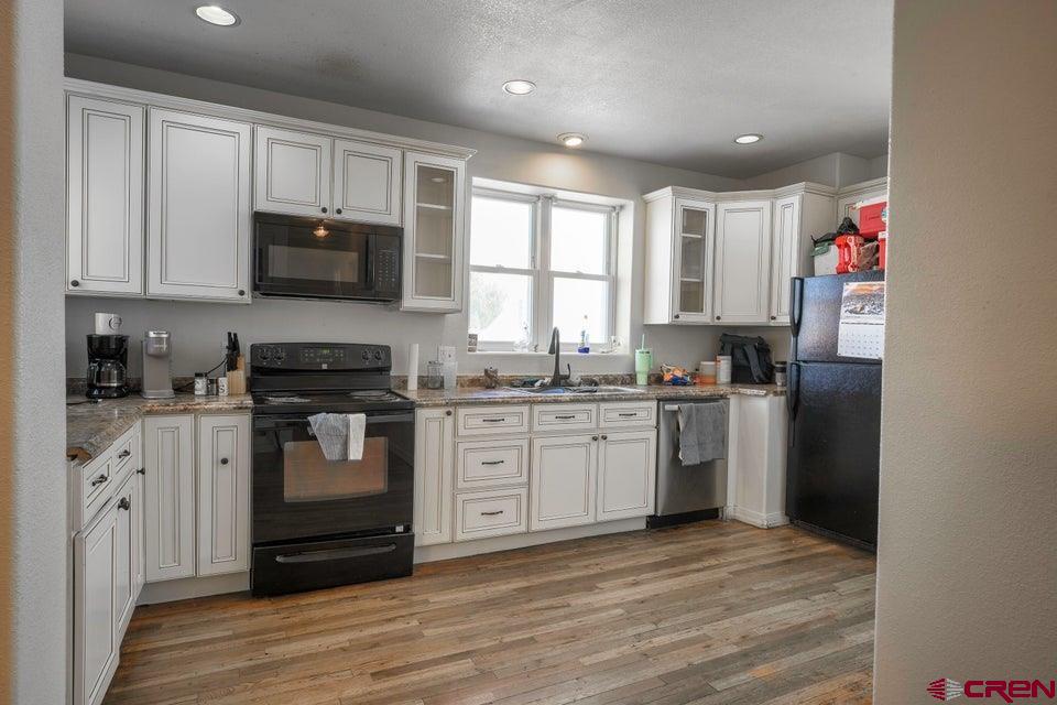 522 East First Street, Unit A & B Trinidad, CO 81082 - Photo 10 of 45 a kitchen with granite countertop a refrigerator stove top oven and sink