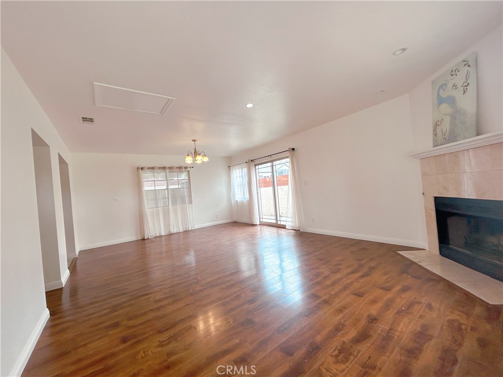 1807 Berkeley Avenue Pomona, CA 91768 - Photo 2 of 8 an empty room with wooden floor and fireplace