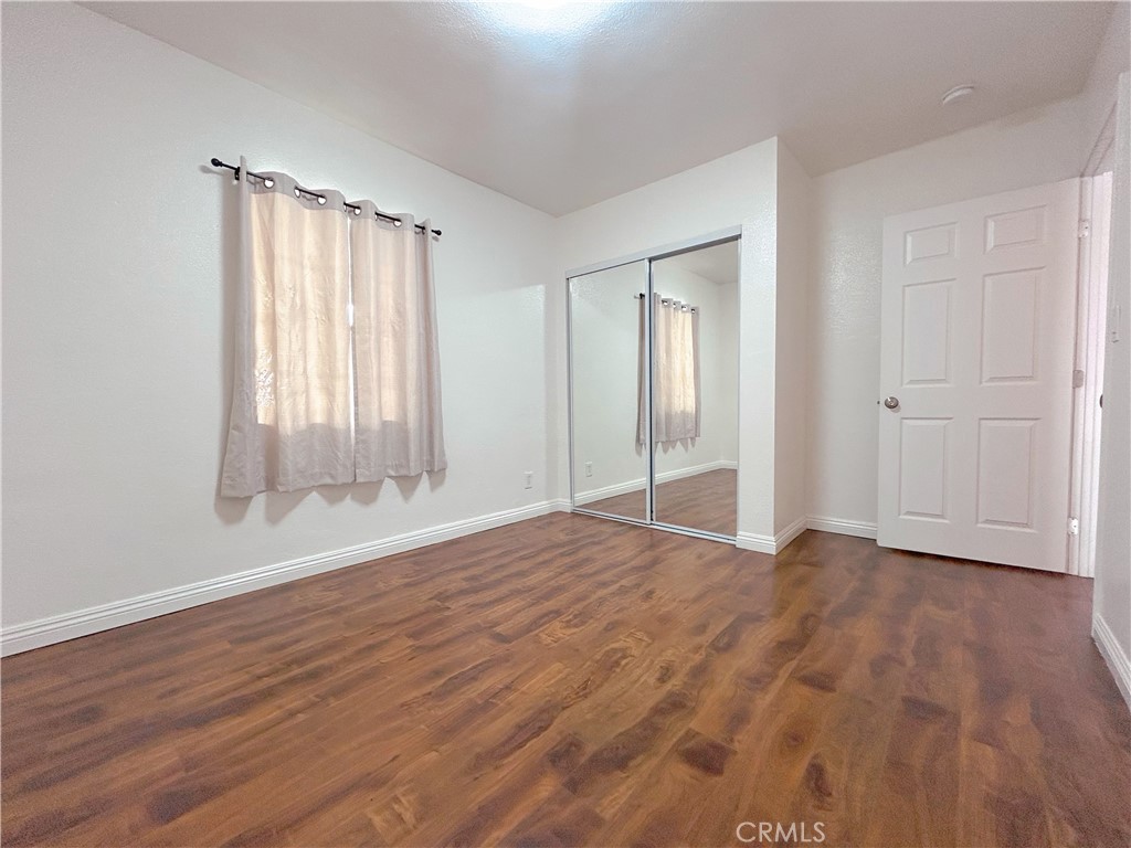 1807 Berkeley Avenue Pomona, CA 91768 - Photo 4 of 8 a view of an empty room with wooden floor and a window