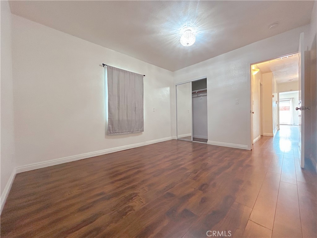1807 Berkeley Avenue Pomona, CA 91768 - Photo 6 of 8 a view of an empty room with wooden floor and a window