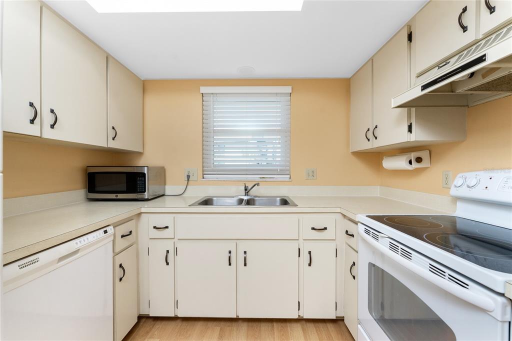 2700 North Beach Road, Unit E107 Englewood, FL 34223 - Photo 16 of 62 a kitchen with cabinets appliances a sink and a counter top