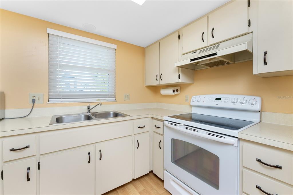 2700 North Beach Road, Unit E107 Englewood, FL 34223 - Photo 19 of 62 a kitchen with white cabinets and white appliances